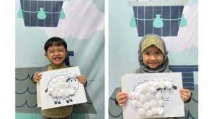 anak memegang hasil karya menempel bulu di domba