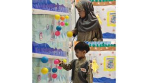 anak melepaskan bola yang menempel di dinding